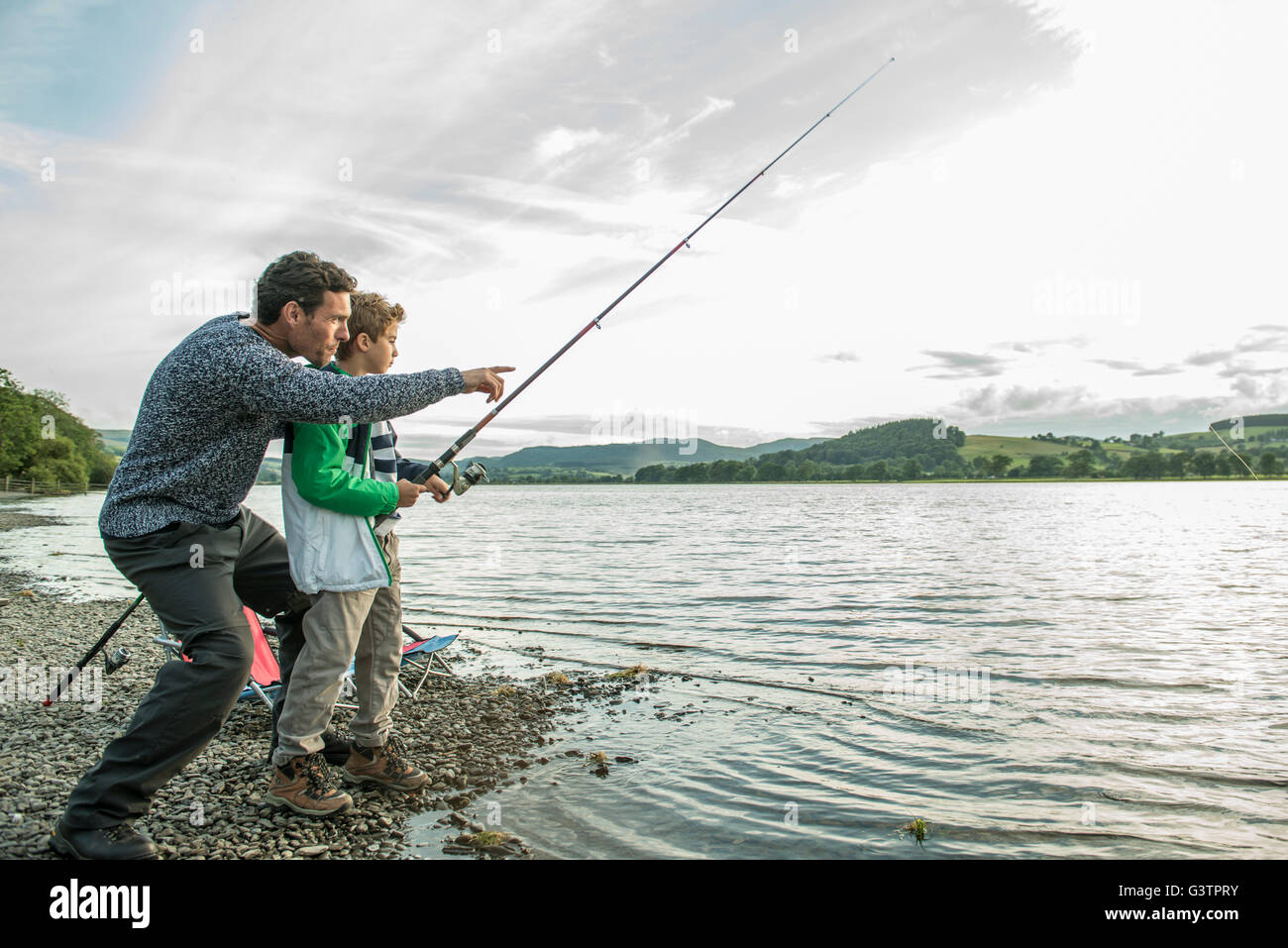 A father and son fishing from the shore of Bala Lake in Wales. Stock Photo