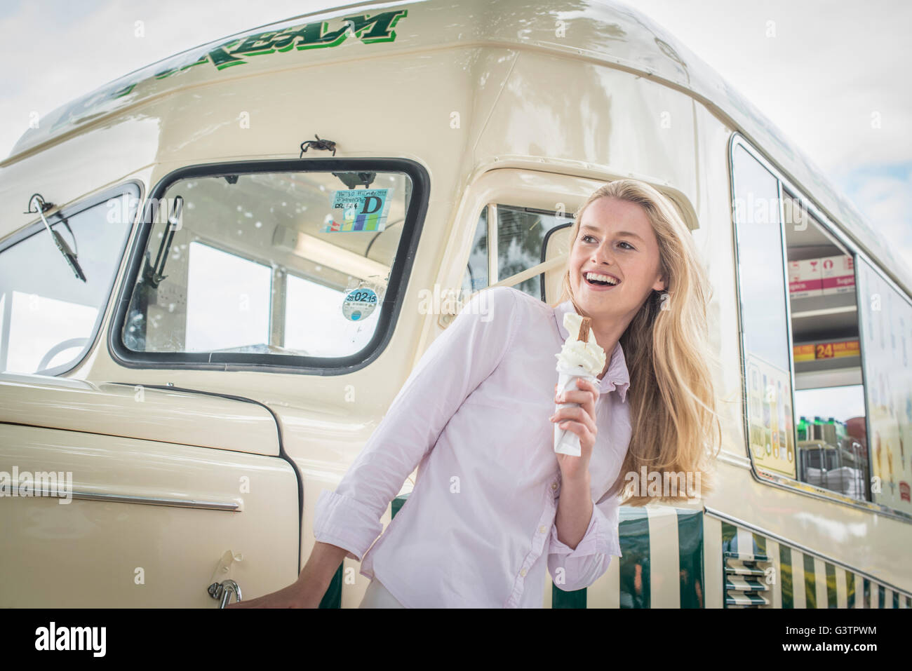A girl standing in front of a traditional ice cream van on the South Bank in London. Stock Photo