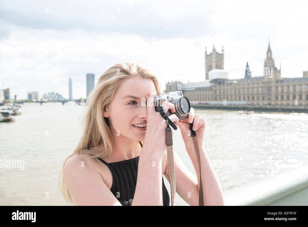 A young woman taking photographs on the South Bank in London. Stock Photo