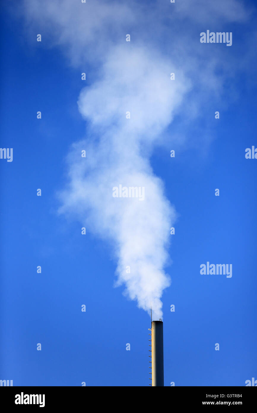 Flue and smoke on blue sky background Stock Photo