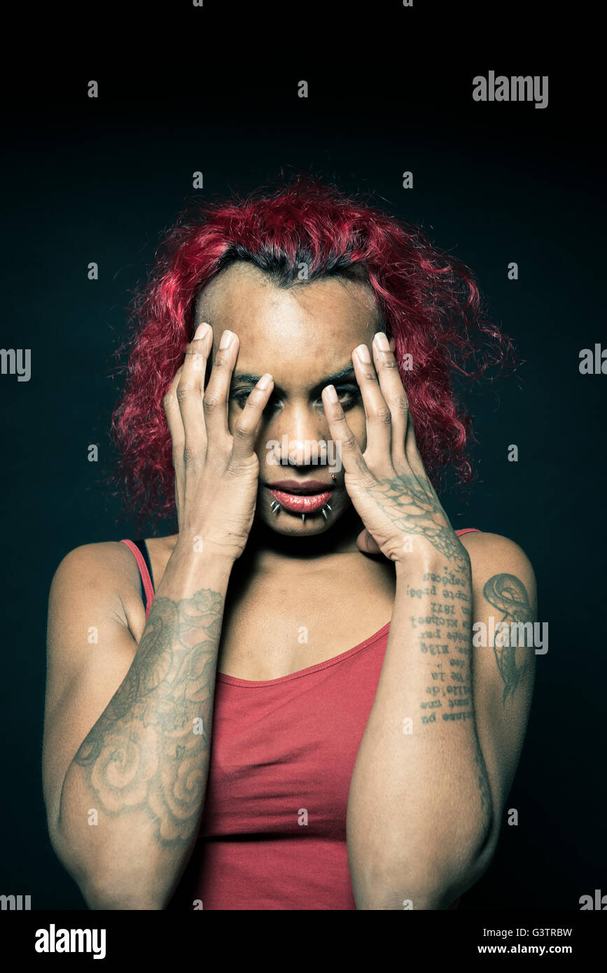 Studio portrait of a young woman with tattooed arms. Stock Photo