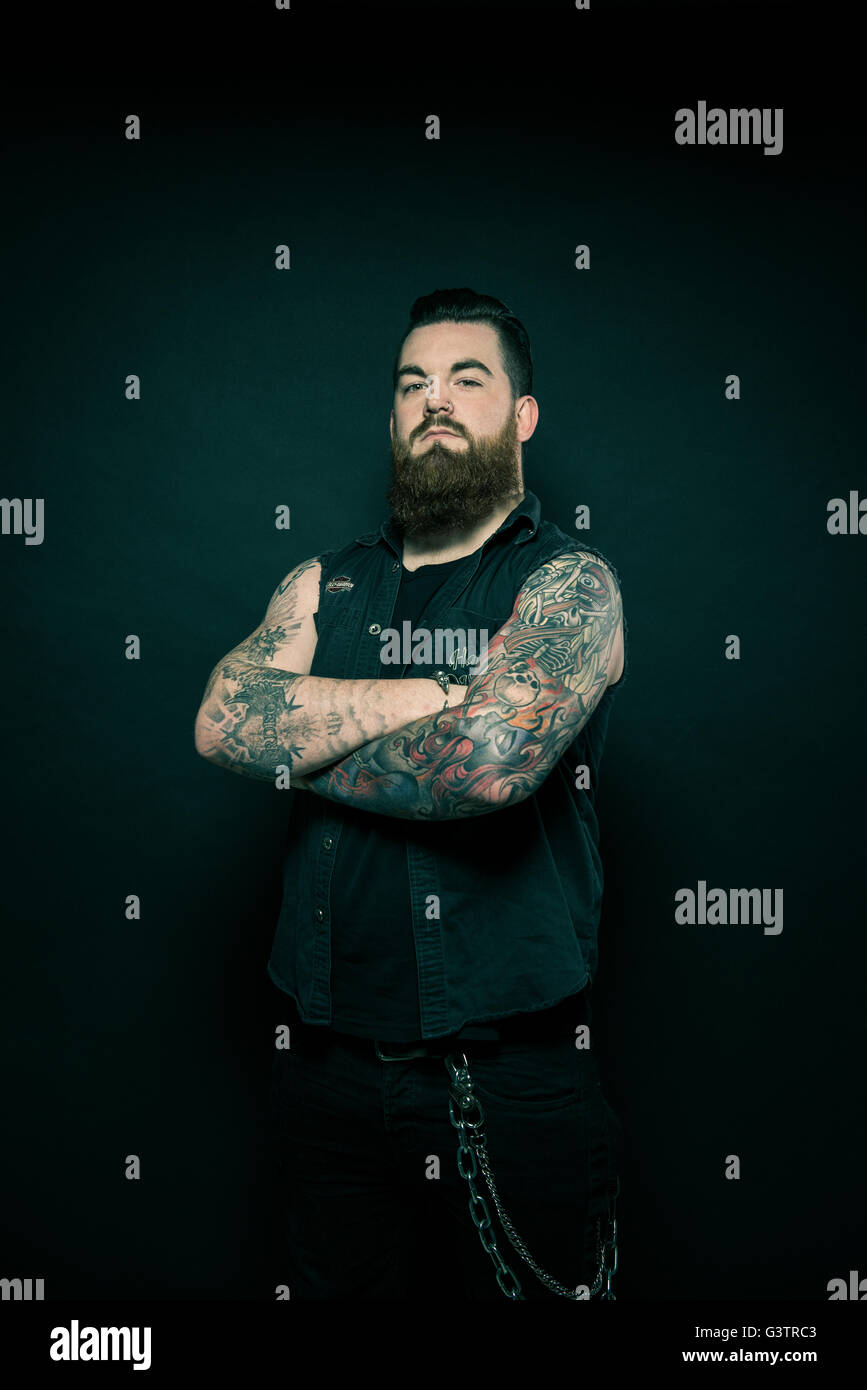 Studio portrait of a bearded man with tattooed arms Stock Photo - Alamy
