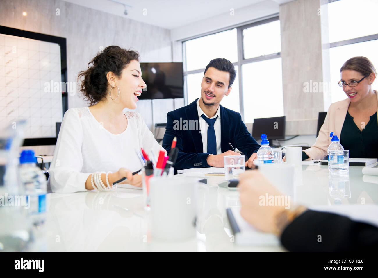 Professional people sitting in an office environment having a discussion during a production meeting. Stock Photo