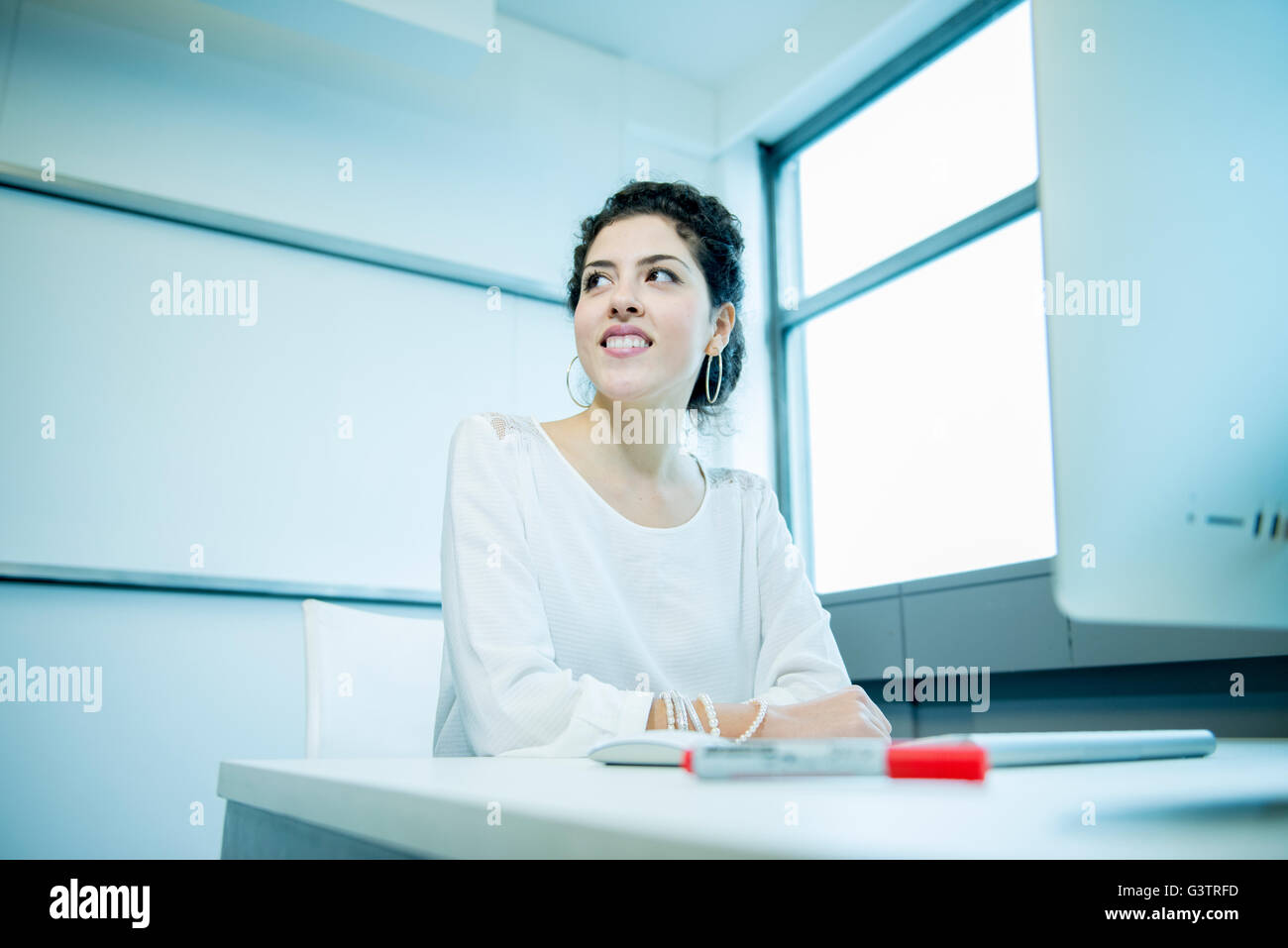 A professional woman sitting in front of a computer in an office environment. Stock Photo