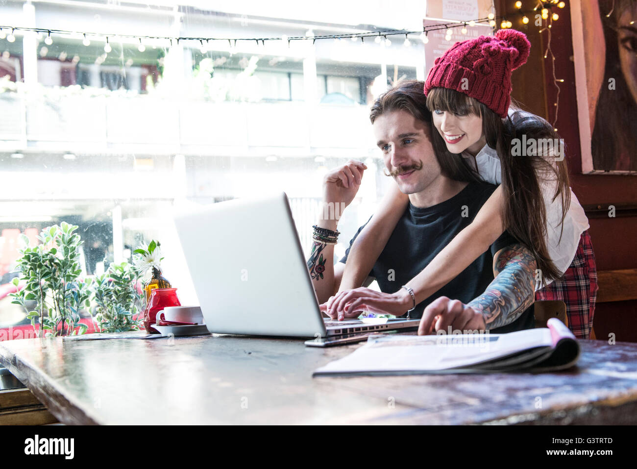 A young couple working at a laptop together in a coffee shop in Manchester. Stock Photo