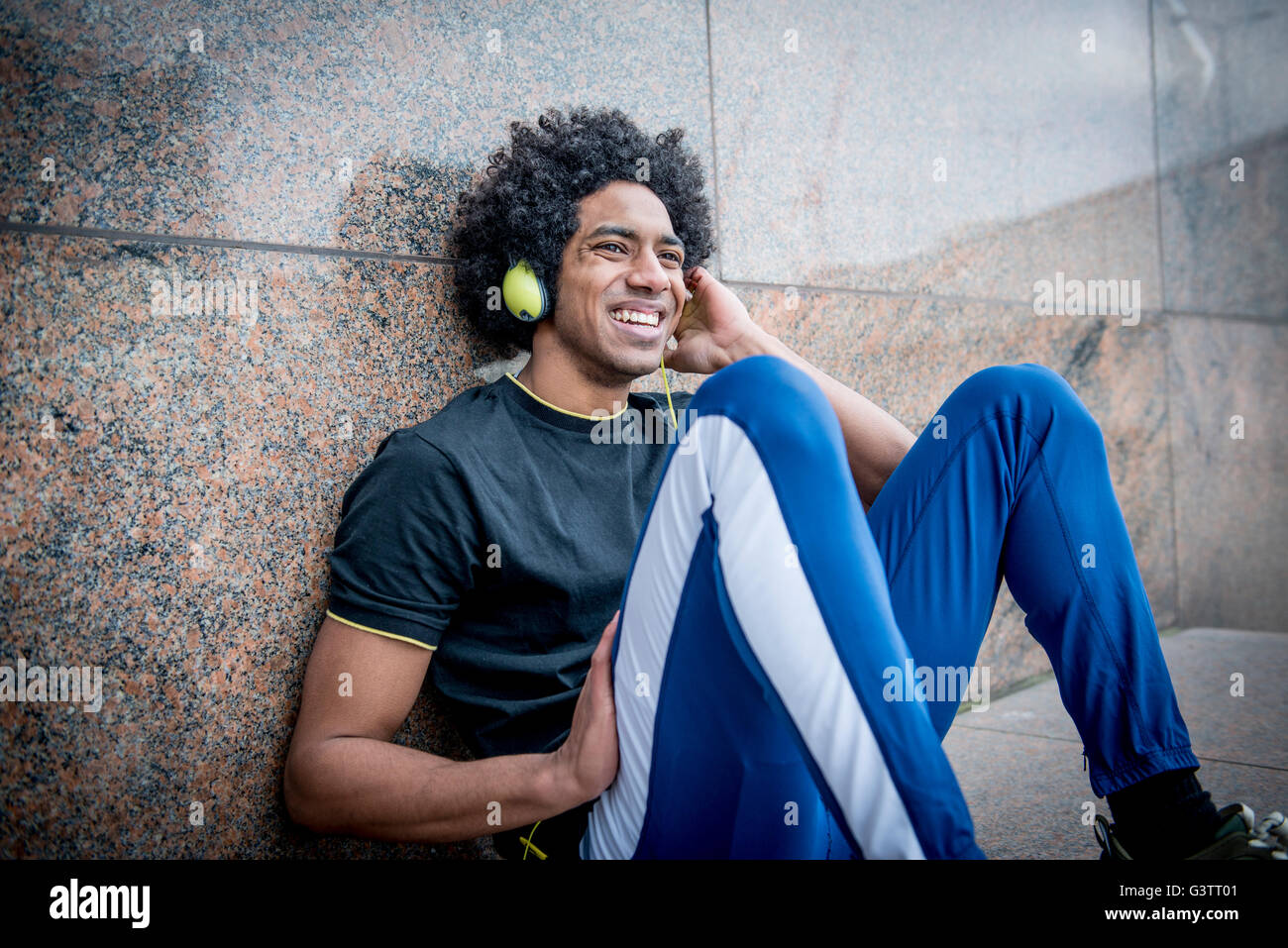 A young man listening to music via headphones on the South Bank in London. Stock Photo