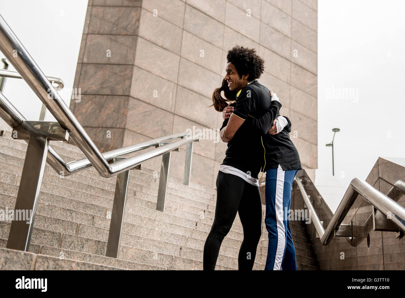 A young couple embracing before a jog along the South Bank in London. Stock Photo