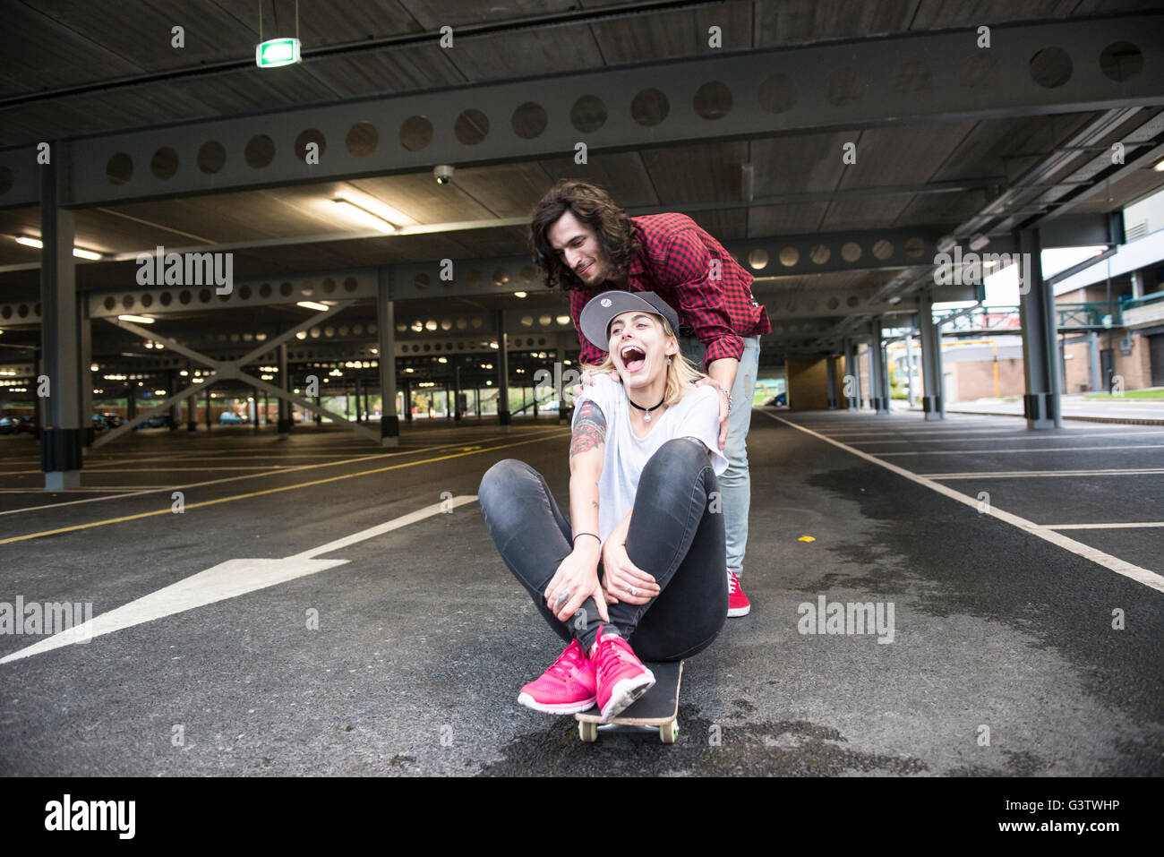 A cool young couple having fun with a skateboard. Stock Photo