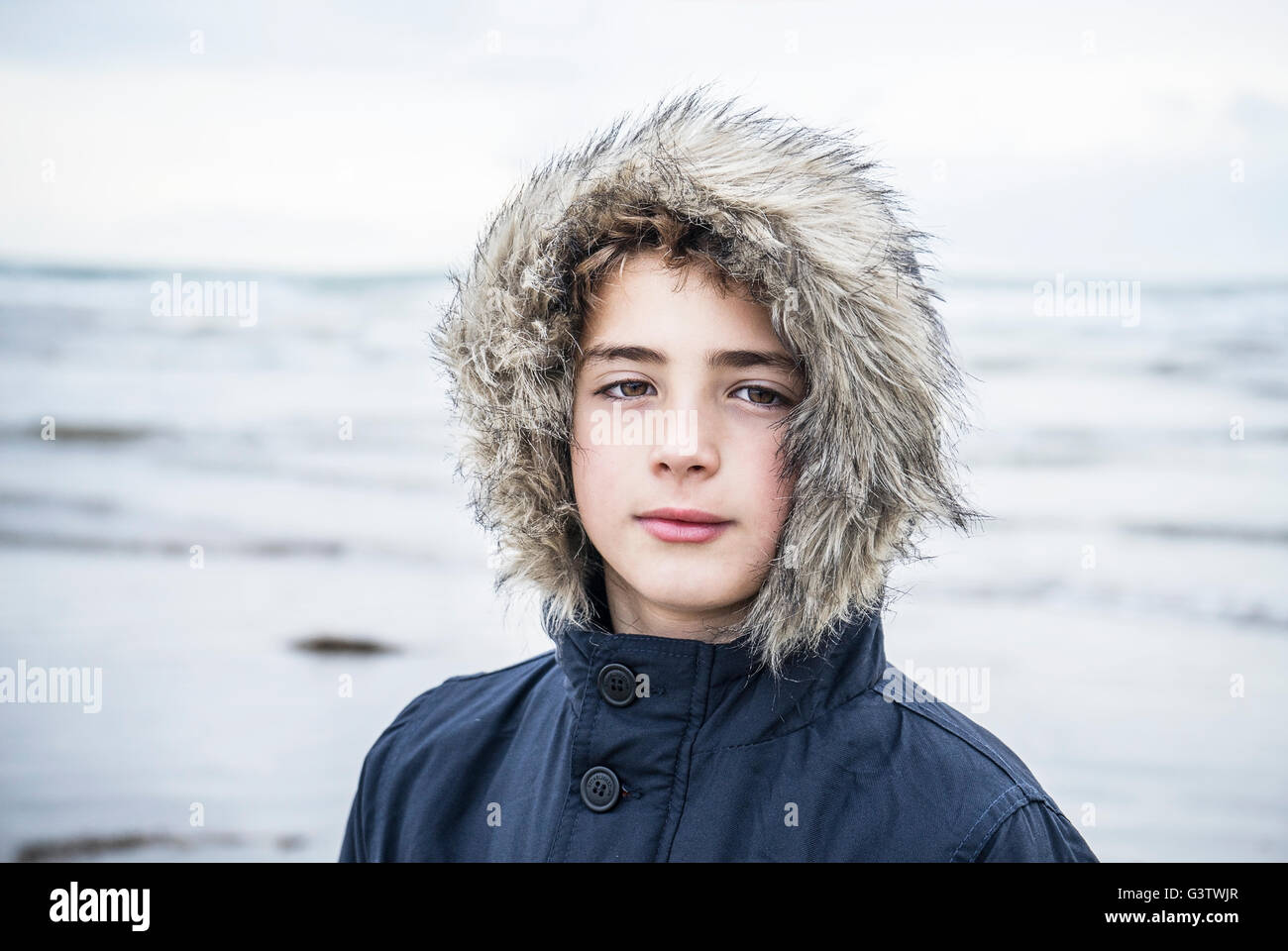 A young boy standing on the beach at Porthmadog. Stock Photo