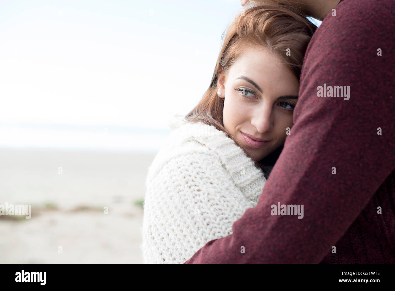 A young couple embracing on the beach at Porthmadog. Stock Photo