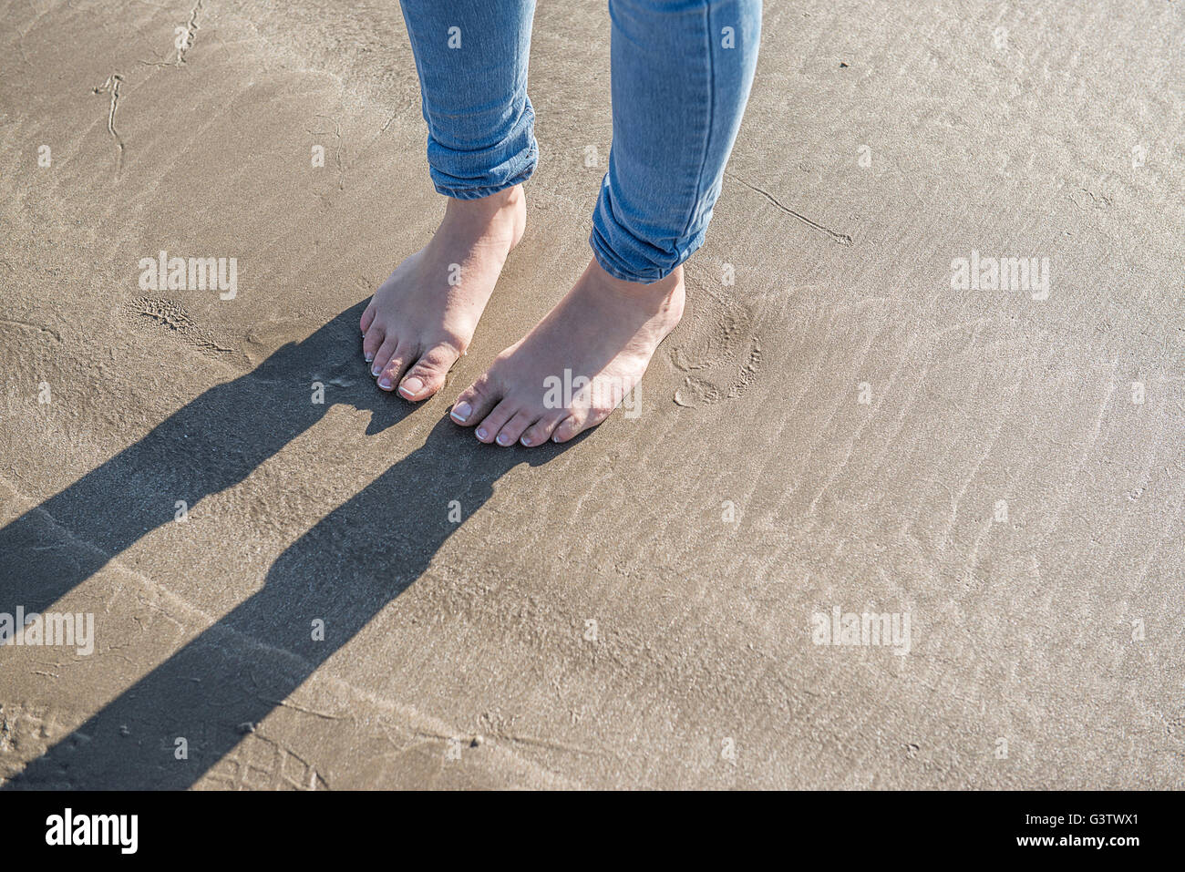 Detail of a young woman's feet on the beach at Porthmadog. Stock Photo