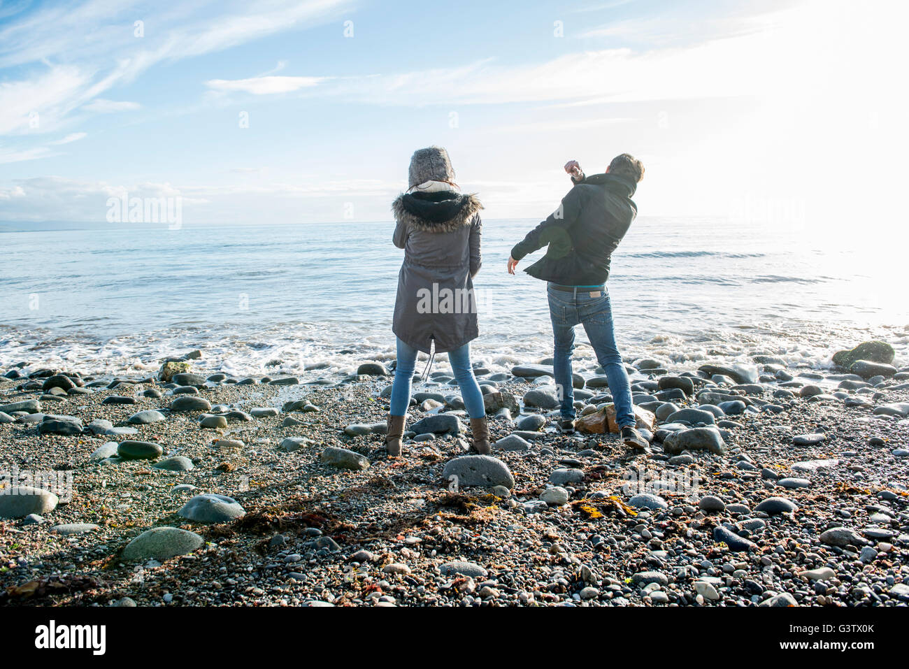 A young couple enjoying the sunshine on the beach at Porthmadog. Stock Photo