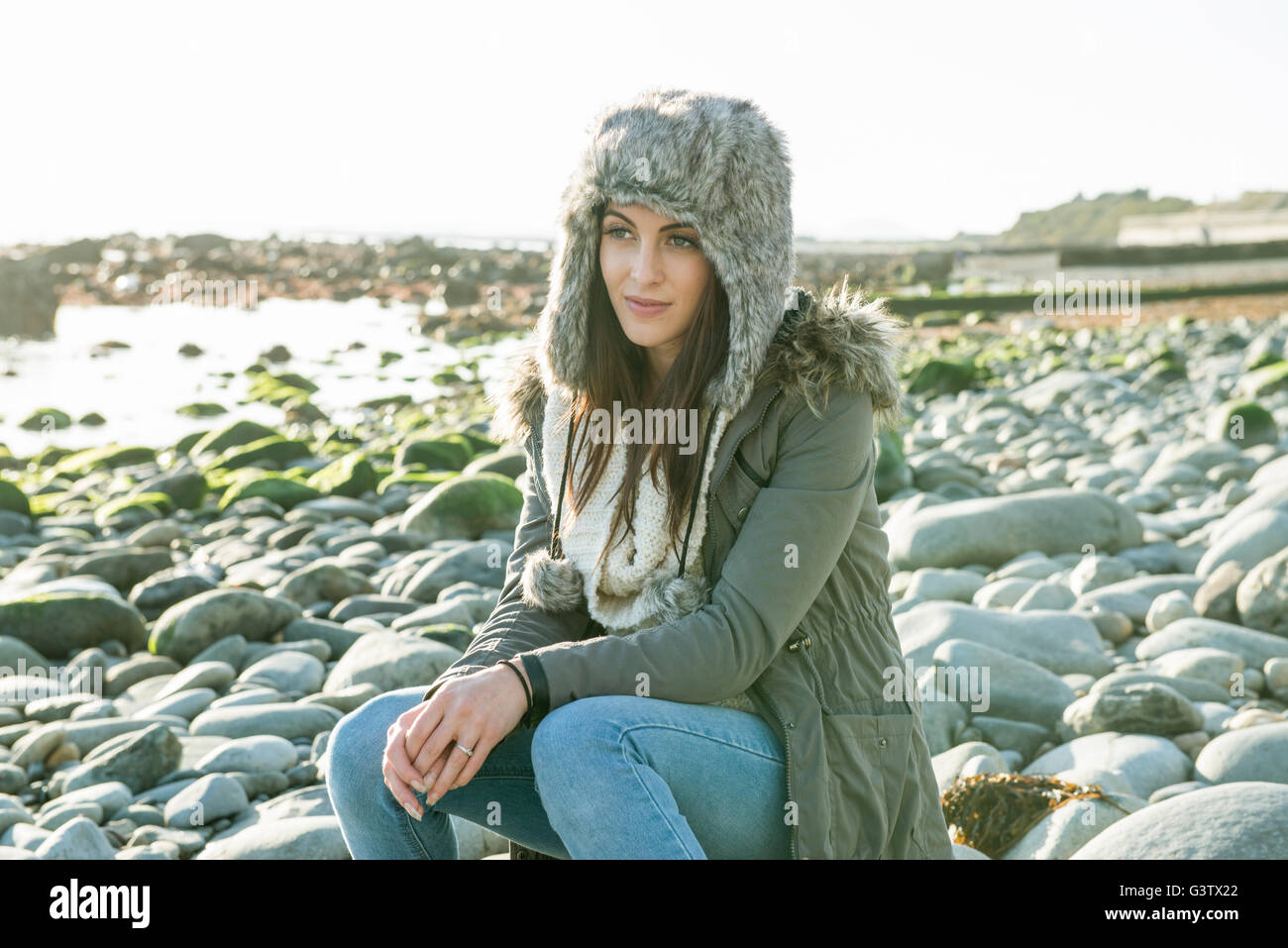 An attractive young woman enjoying the sunshine on the beach at Porthmadog. Stock Photo