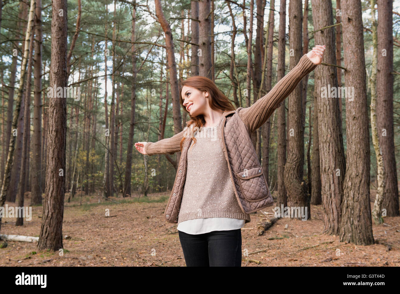 A young woman communing with nature in a forest in Autumn. Stock Photo