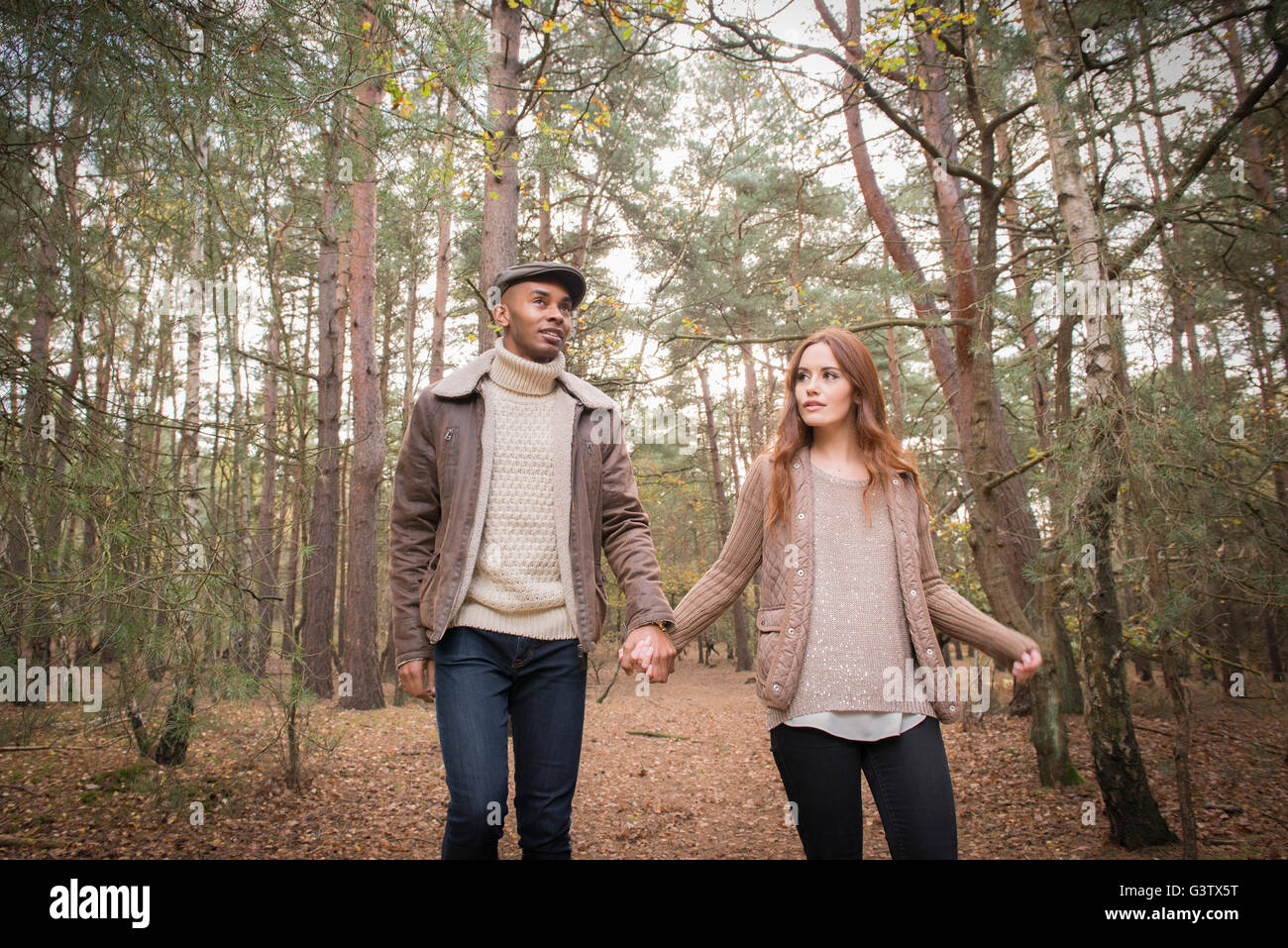 A young couple enjoying a forest walk in Autumn Stock Photo - Alamy