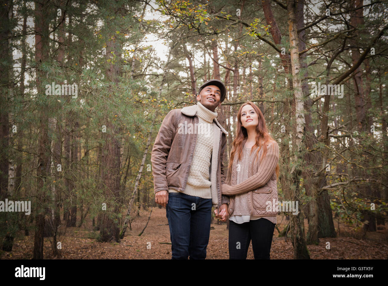 A young couple enjoying a forest walk in Autumn Stock Photo - Alamy