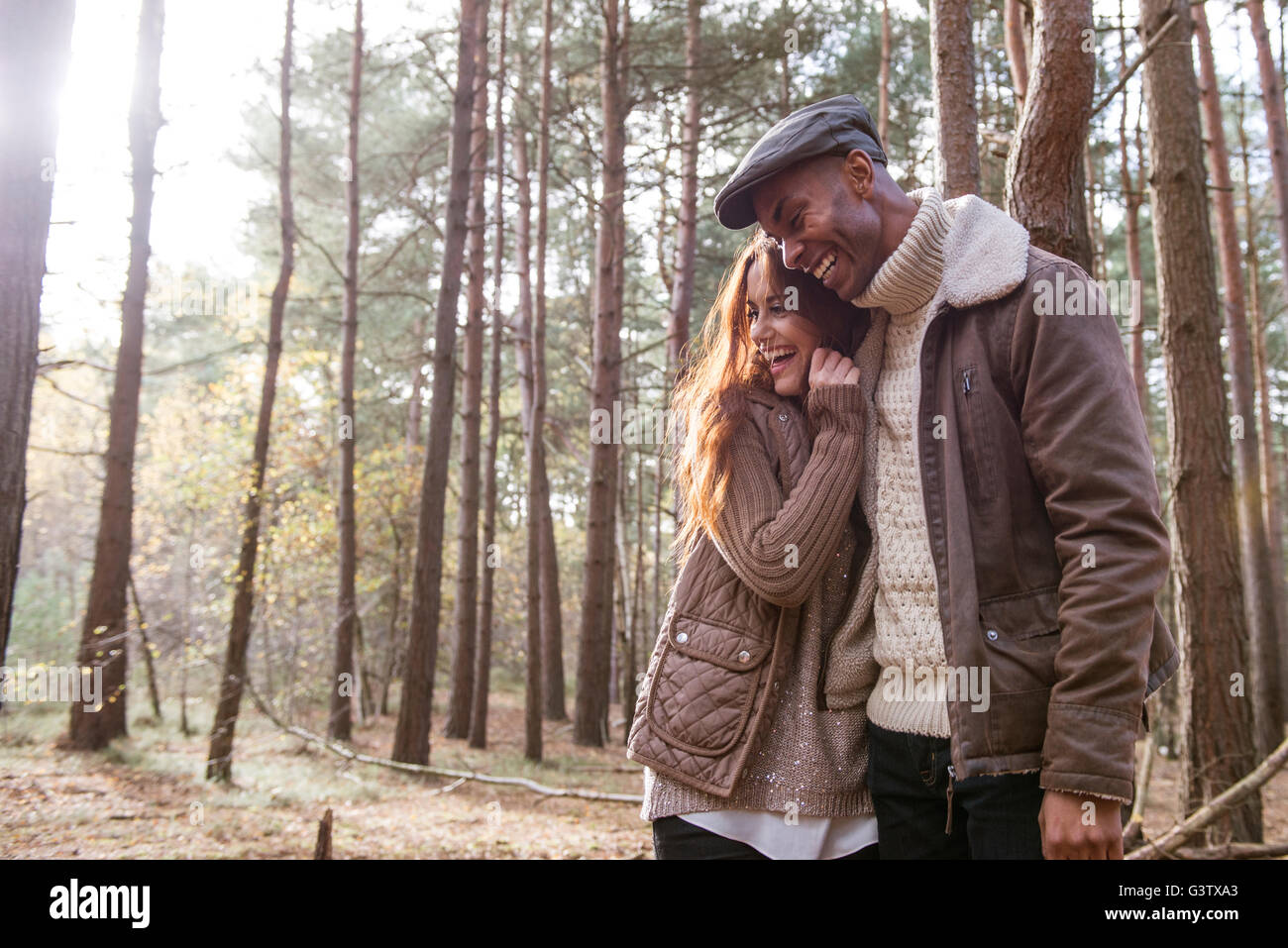 A young couple cuddling on a forest walk in Autumn. Stock Photo