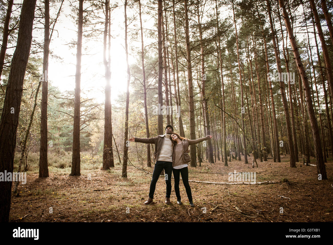 A young couple communing with nature on a forest walk in Autumn. Stock Photo