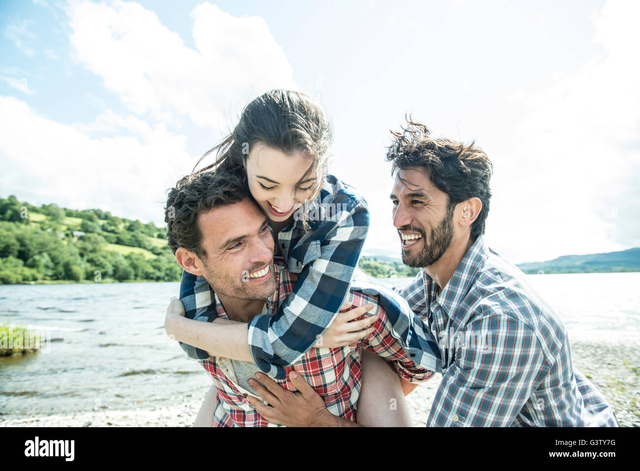 Three friends having fun on the shore of Bala Lake in Wales. Stock Photo