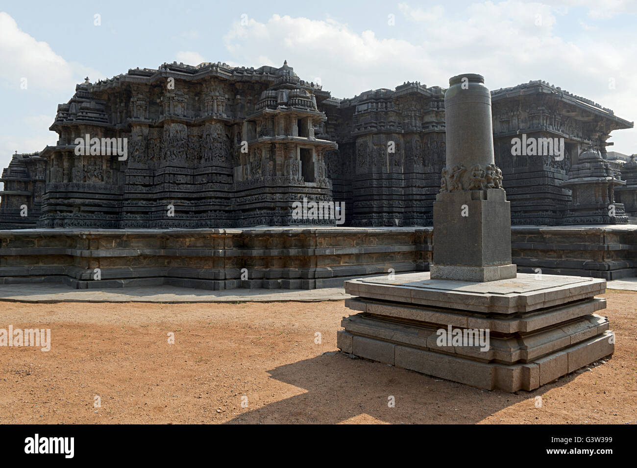 Garuda pillar in front and Hoysaleshwara temple in the background, Halebidu, Karnataka, india. View from South West. Stock Photo
