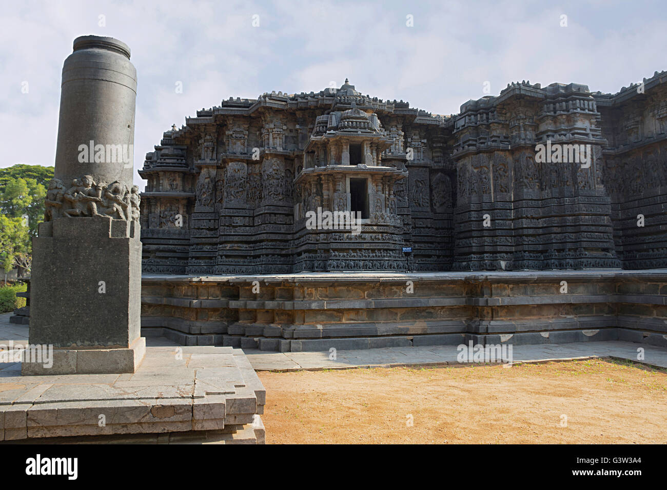 Garuda pillar on the left and Hoysaleshwara temple in the background, Halebidu, Karnataka, india. View from South. Stock Photo