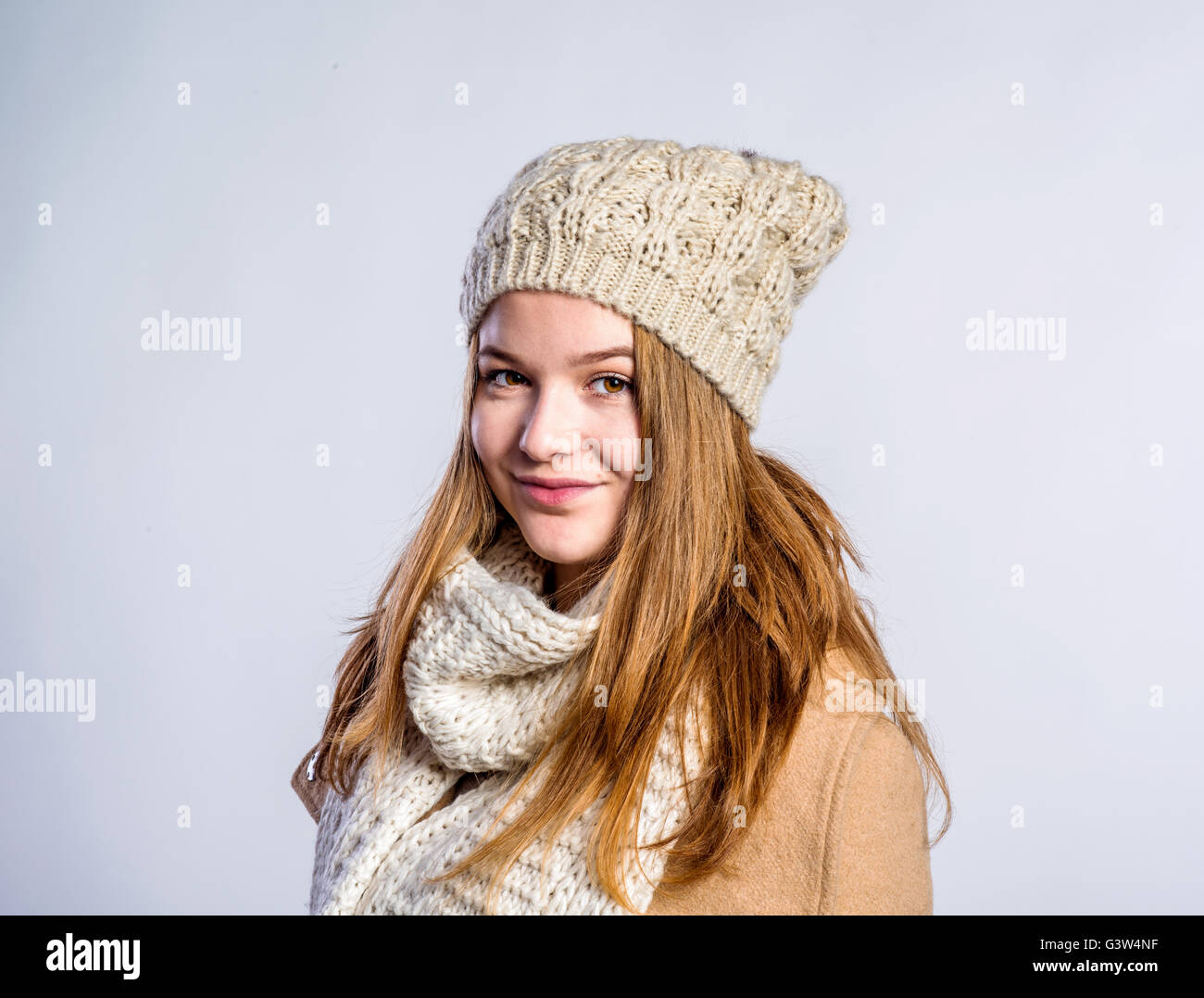Girl in brown coat, scarf and hat, studio shot Stock Photo - Alamy
