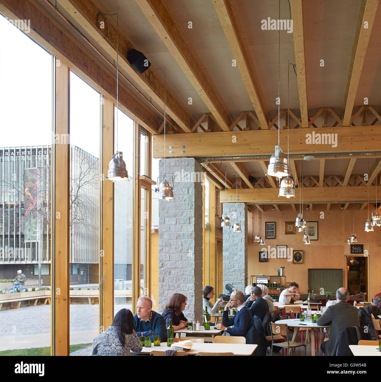 Restaurant seating next to full-height glazing. The Green Room, London, United Kingdom. Architect: Benjamin Marks, 2015. Stock Photo