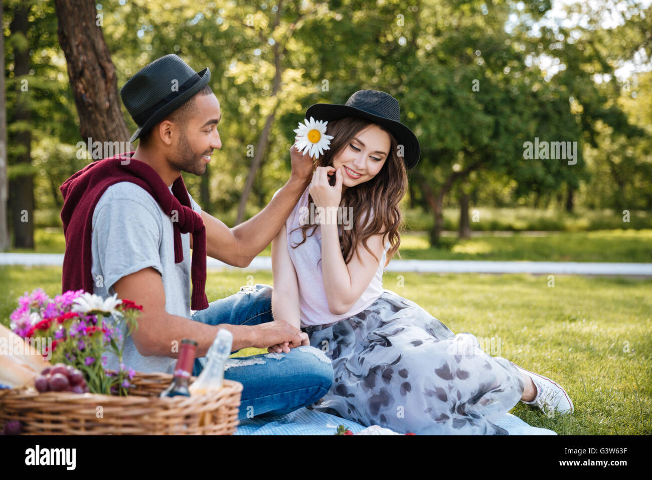 Lifestyle, happy couple resting at a picnic in the park with a dog ...