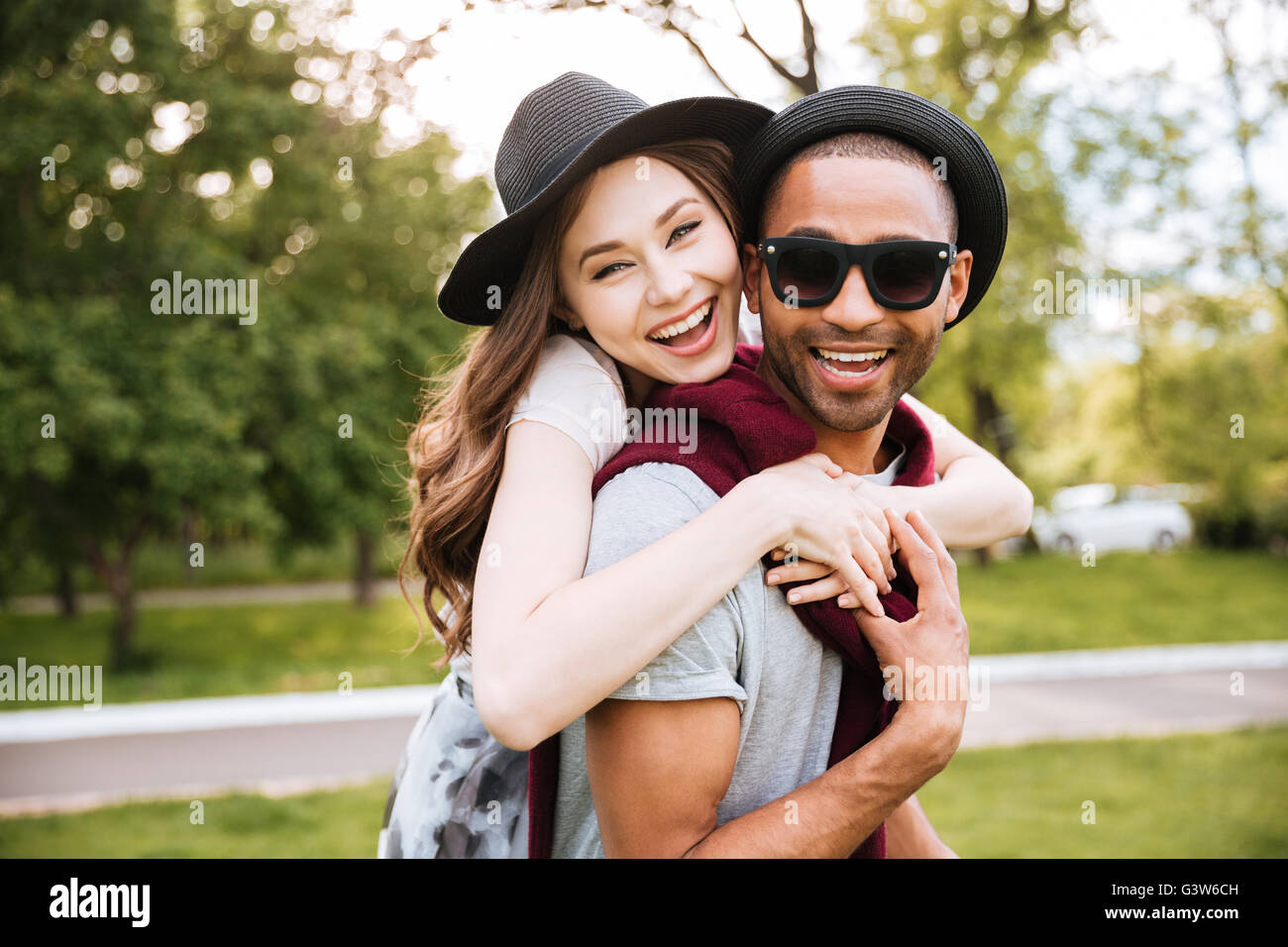 Cheerful young couple hugging and laughing in park Stock Photo - Alamy