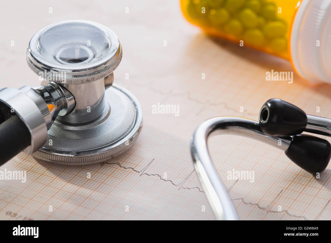 Stethoscope and pill bottle lying on EKG results Stock Photo