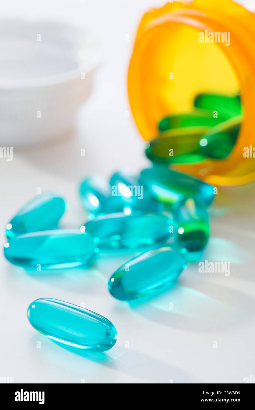 Blue capsules by pill bottle Stock Photo