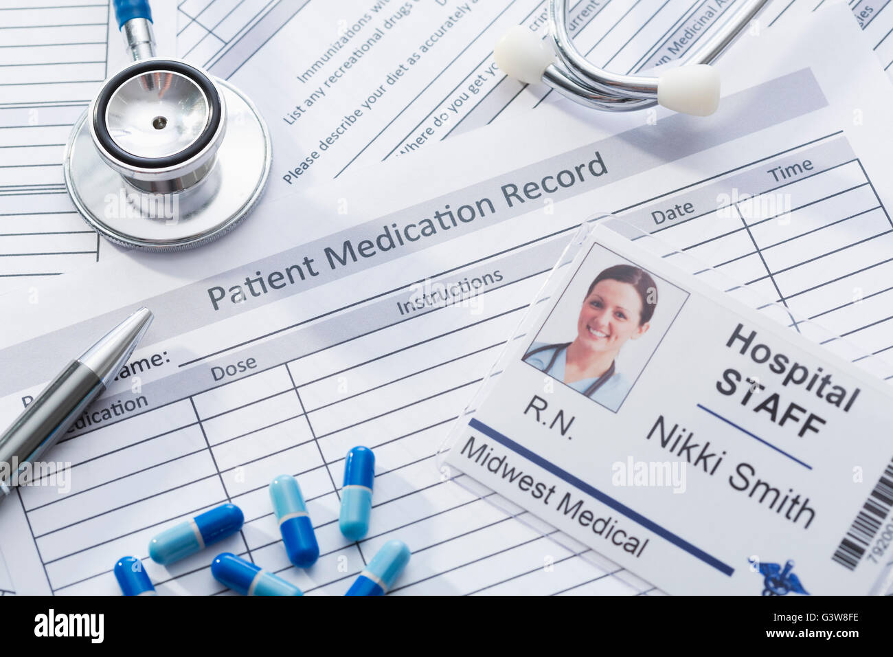 Stethoscope, pills and name tag on medical record Stock Photo