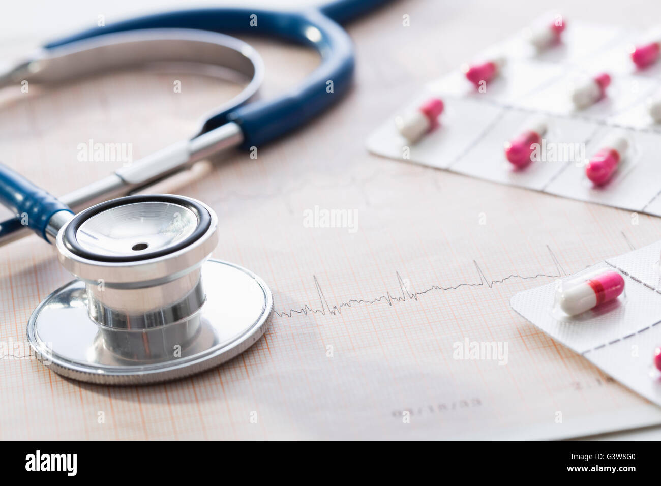 Stethoscope and pills on EKG test graph Stock Photo