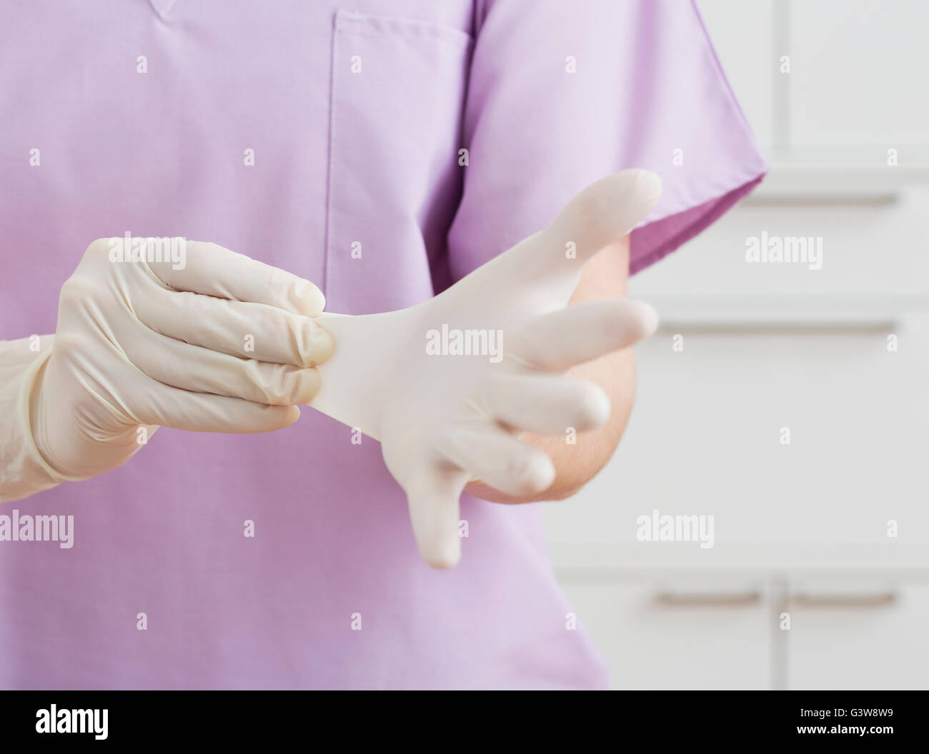 Nurse putting on latex gloves Stock Photo