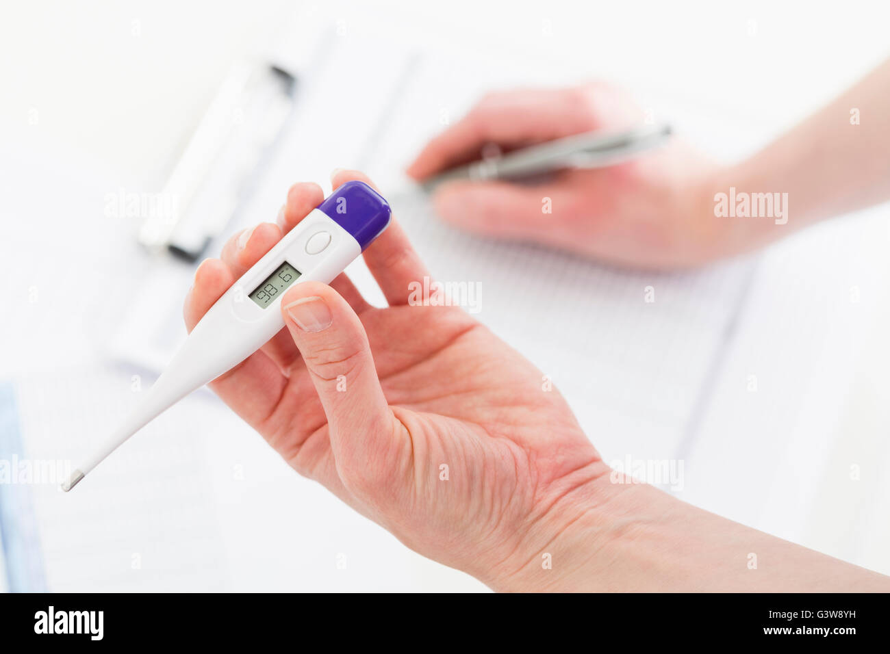 Hand holding thermometer Stock Photo