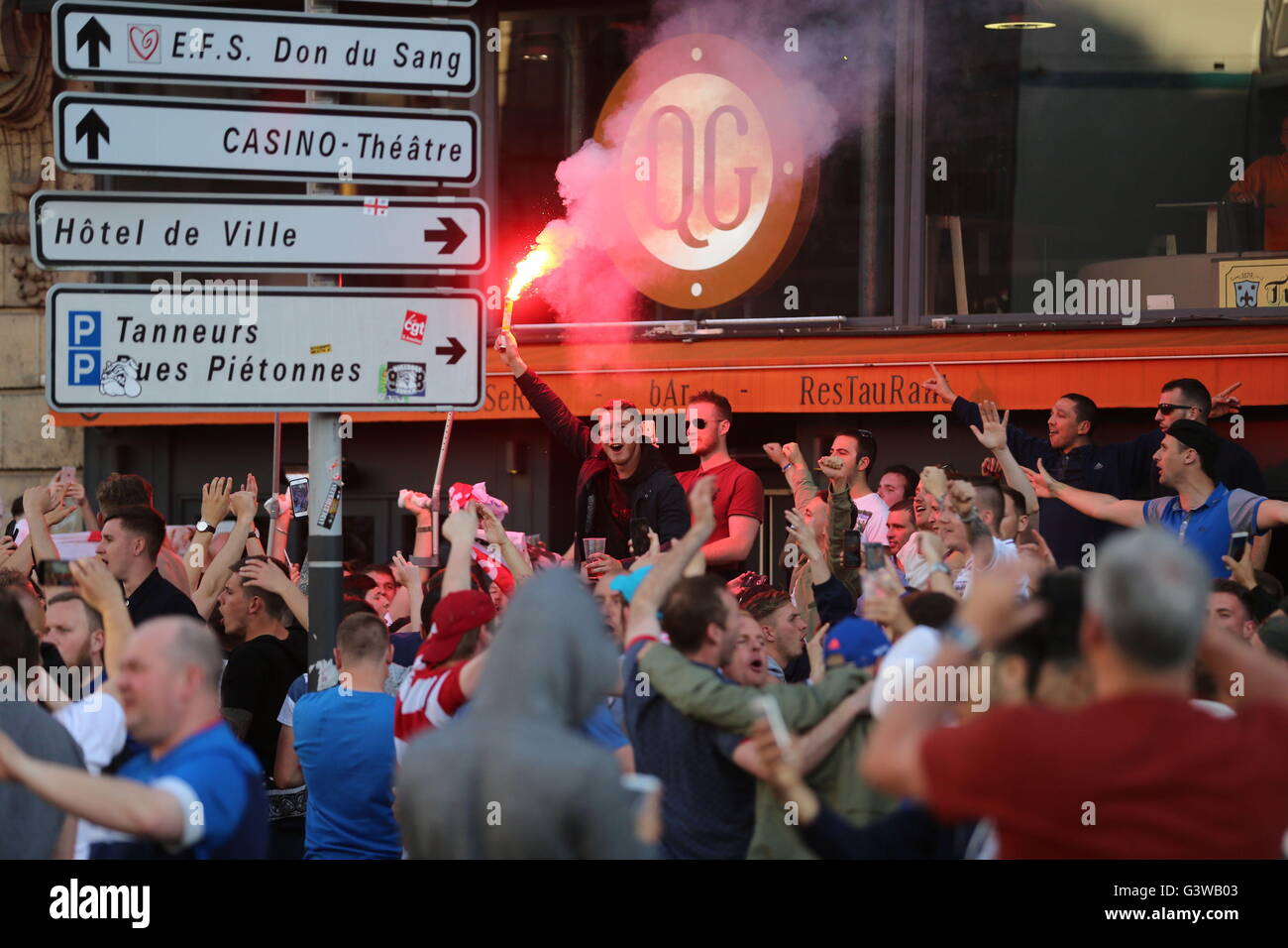 A flare is waved by an England fan in Lille city centre, France, as fresh clashes have taken place between England fans and Russian hooligans at Euro 2016. Stock Photo