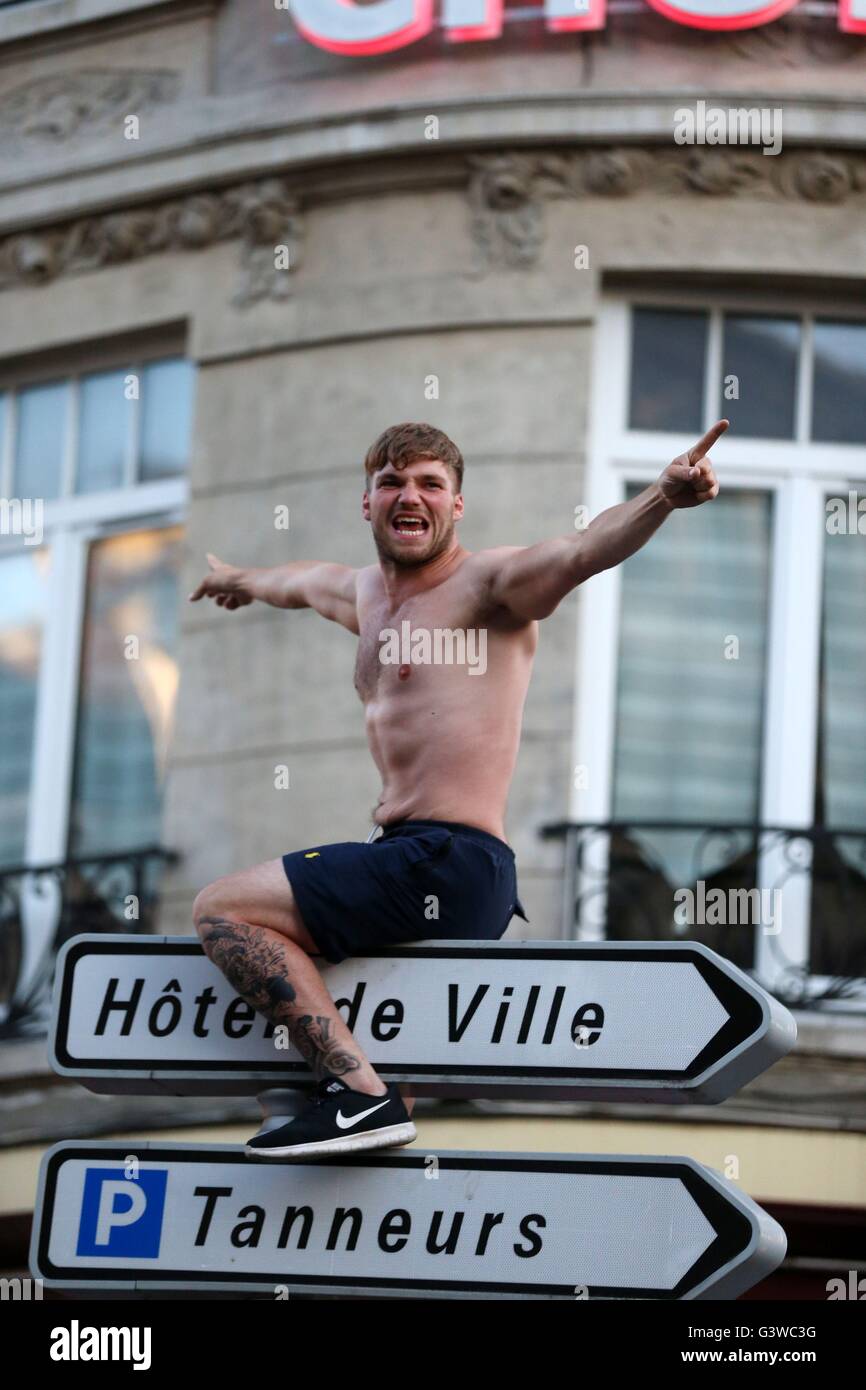 An England fan climbs a signpost in Lille city centre, France, as fresh clashes have taken place between England fans and Russian hooligans at Euro 2016. Stock Photo