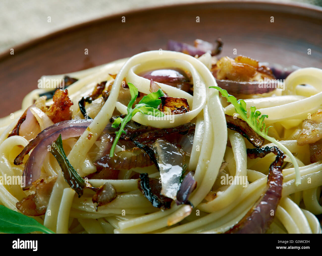 Tagliatelle alla trevisana. Italian pasta with fried  bacon and onions.Venetian cuisine Stock Photo