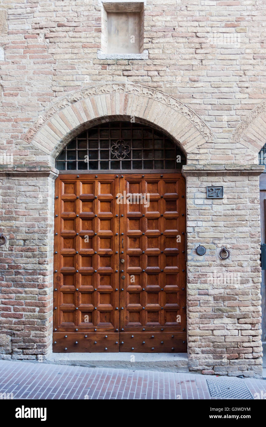 Wooden door entrance in old palace, Tuscany. Stock Photo