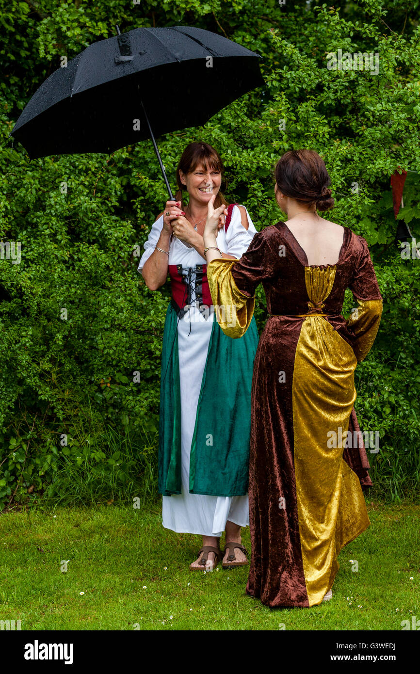 Local Women In Costume Stand Under An Umbrella At The Annual Medieval