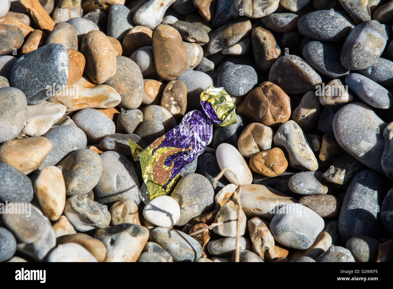 A Cadburys Eclair wrapper on Weybourne Beach, Norfolk. Stock Photo