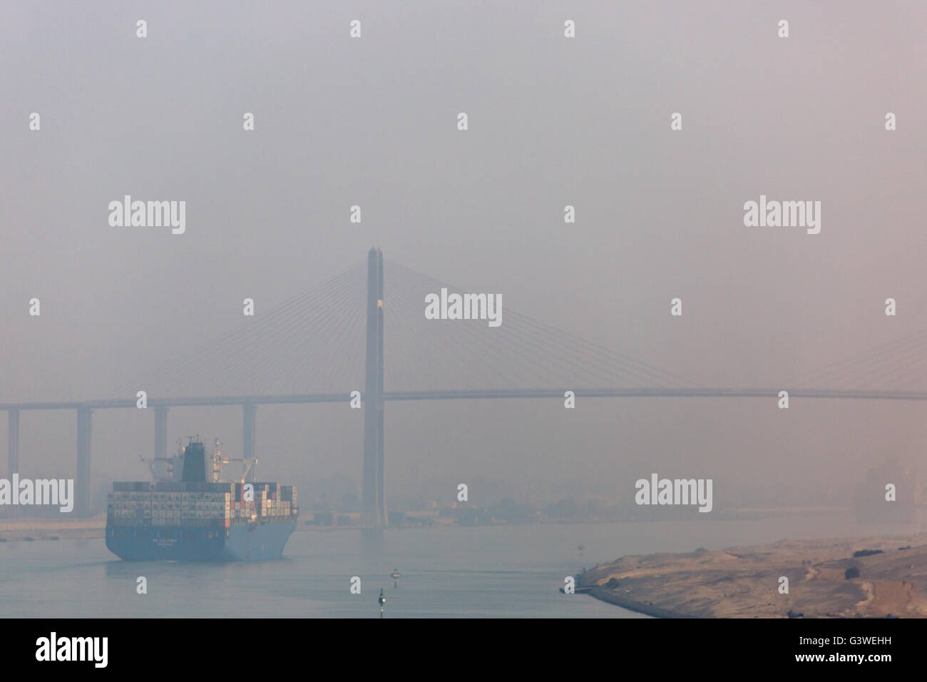 Ship sailing up the Suez Canal through Desert morning fog. Egypt. Stock Photo