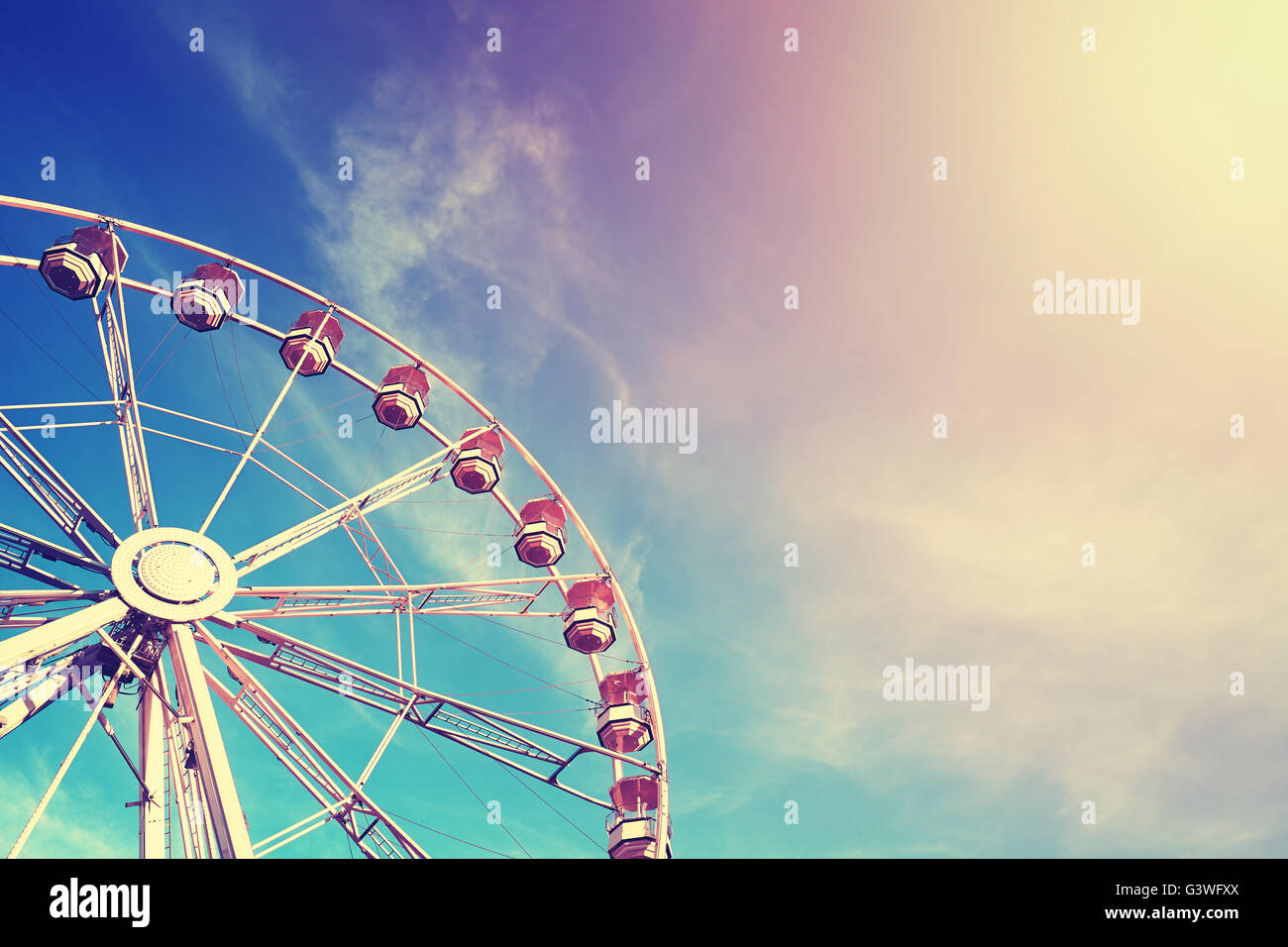 Vintage stylized ferris wheel at sunset, space for text. Stock Photo