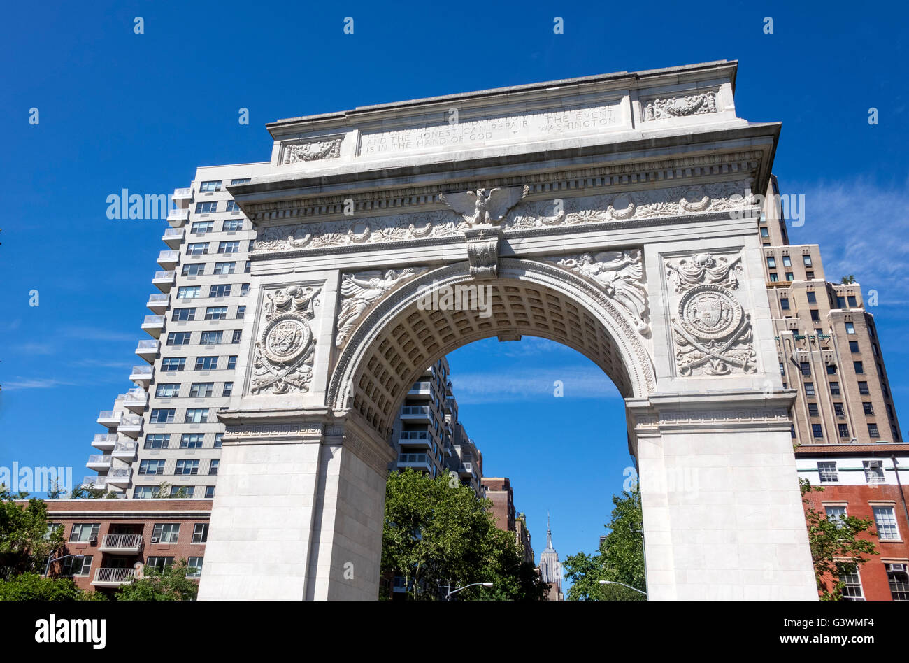 The Washington Square Arch at the bottom of Fifth Avenue in Greenwich Village in New York City, with the Empire State Building Stock Photo