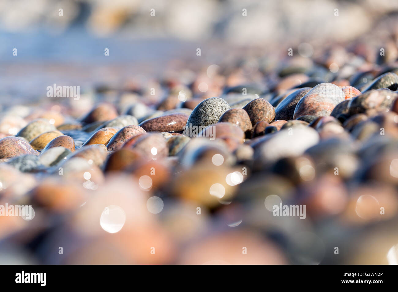 Colorful beach stones cover the shoreline of Crisp Point Beach on the edge of Lake Superior in the Upper Peninsula of Michigan Stock Photo