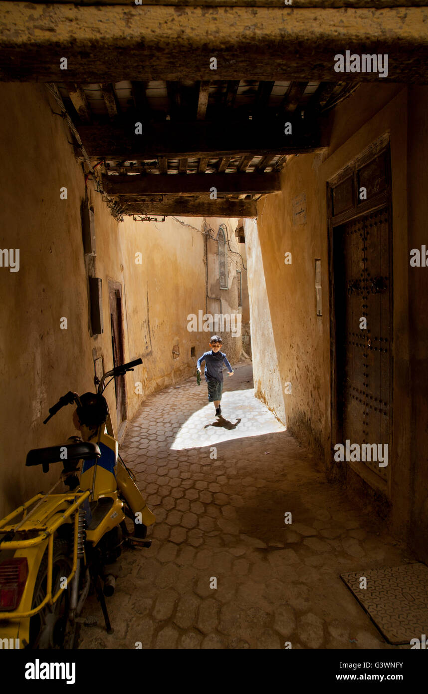 Boy running in the narrow street of Fez ( Fes Fas ) city, UNESCO heritage site in Morocco, Africa Stock Photo