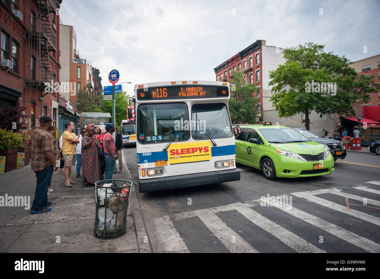 Commuters board an M116 bus in the Harlem neighborhood of New York on