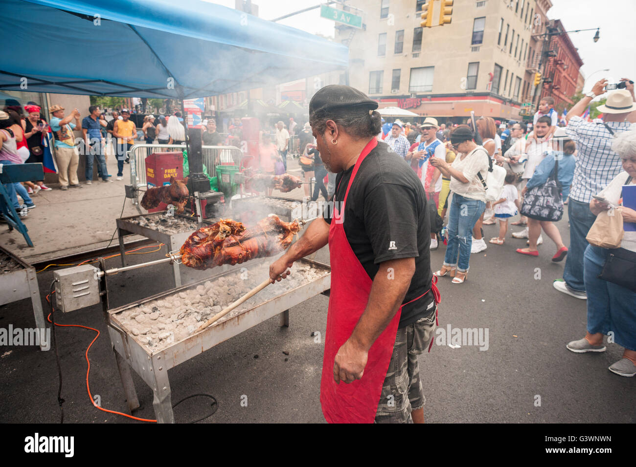 A chef prepares roast pigs at the 31st 116th Street Festival