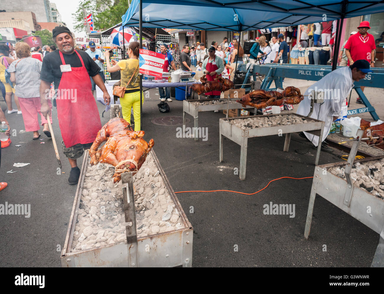 A chef prepares roast pigs at the 31st 116th Street Festival