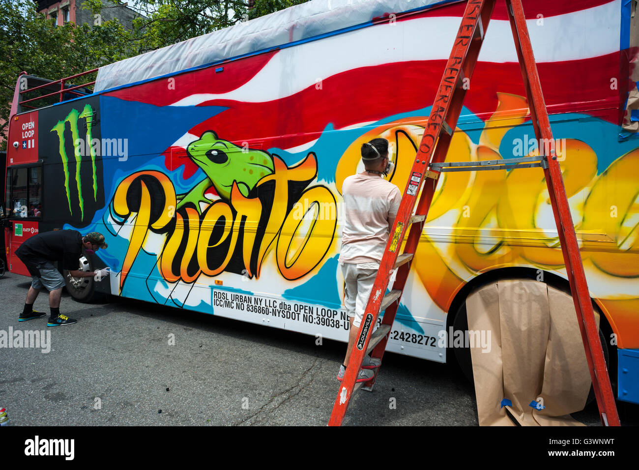 Artists decorate a Monster Beverage bus in a Puerto Rican theme at the 31st 116th Street Festival celebrating Puerto Rican heritage in New York on Saturday, June 11, 2016. The festival held in El Barrio on the day prior to the parade is the largest latin festival in the Northeast. (© Richard B. Levine) Stock Photo